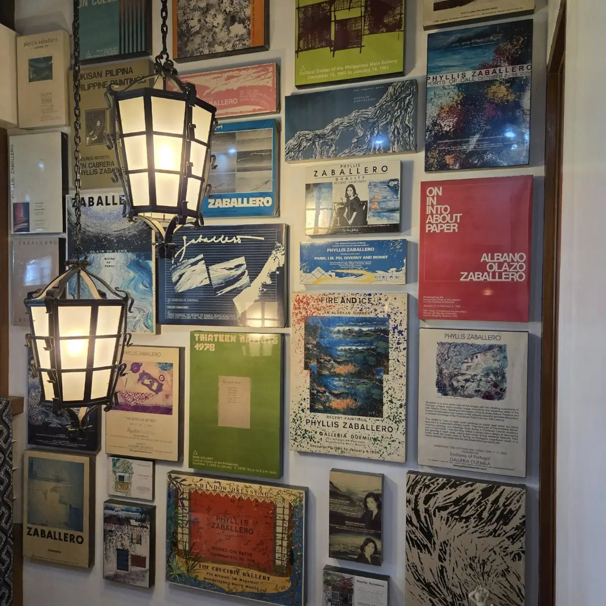 Artist in studio surrounded by paintings, sketches, and materials during creative process