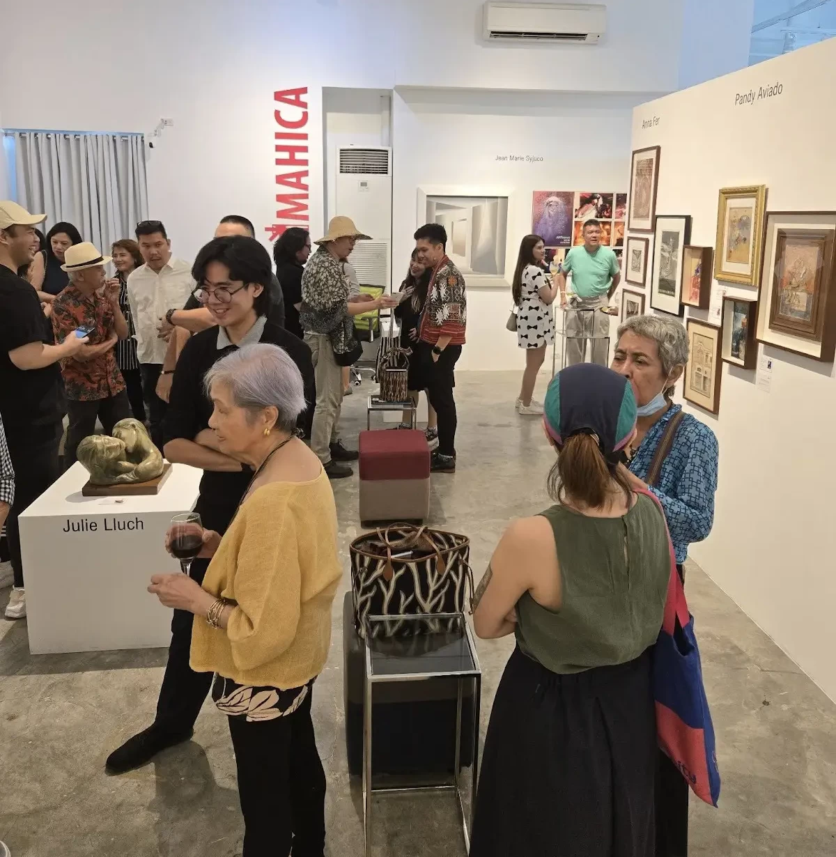 Participating artists and guests mingling at the opening of “Timeless Strokes”